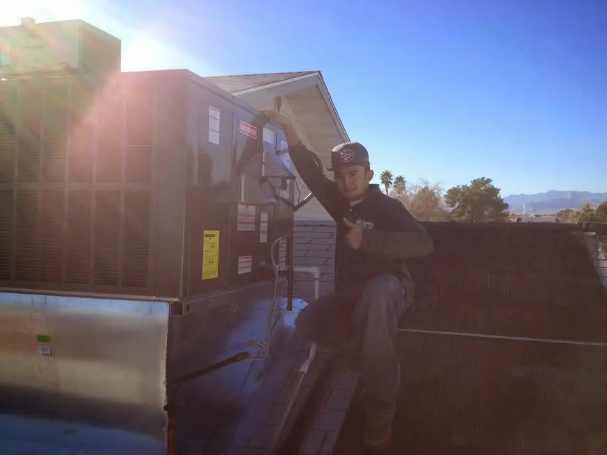 HVAC technician performing Air Duct Cleaning on a rooftop unit in Gastonia